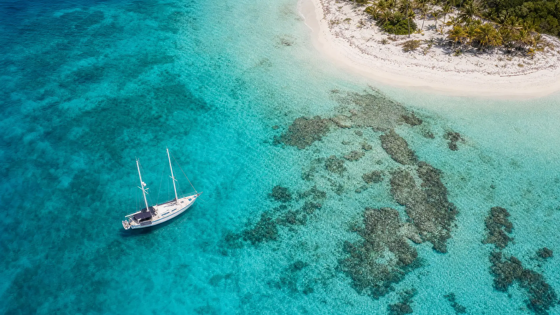 Aerial view of the Belize reef: turquoise lagoon, coral patches and a white sandbar